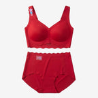 A two-piece red lingerie set consisting of a bralette with scalloped edges and a matching high-waisted brief, laid flat on a white background. The bralette features a small floral applique on the shoulder strap.