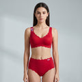 A woman modeling a matching red two-piece underwear set with scalloped edges, featuring a bra top and high-waisted briefs, against a light gray studio background.